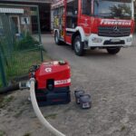 PFPN fördert Wasser aus dem Löschteich. Im Hintergrund steht das LF10 der Ortsfeuerwehr Quarnbek.